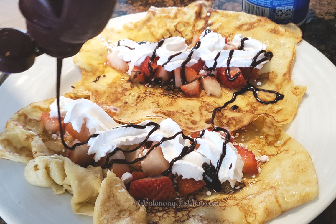 Easy Cinnamon Crepes Made To Order, topped with strawberries and chocolate